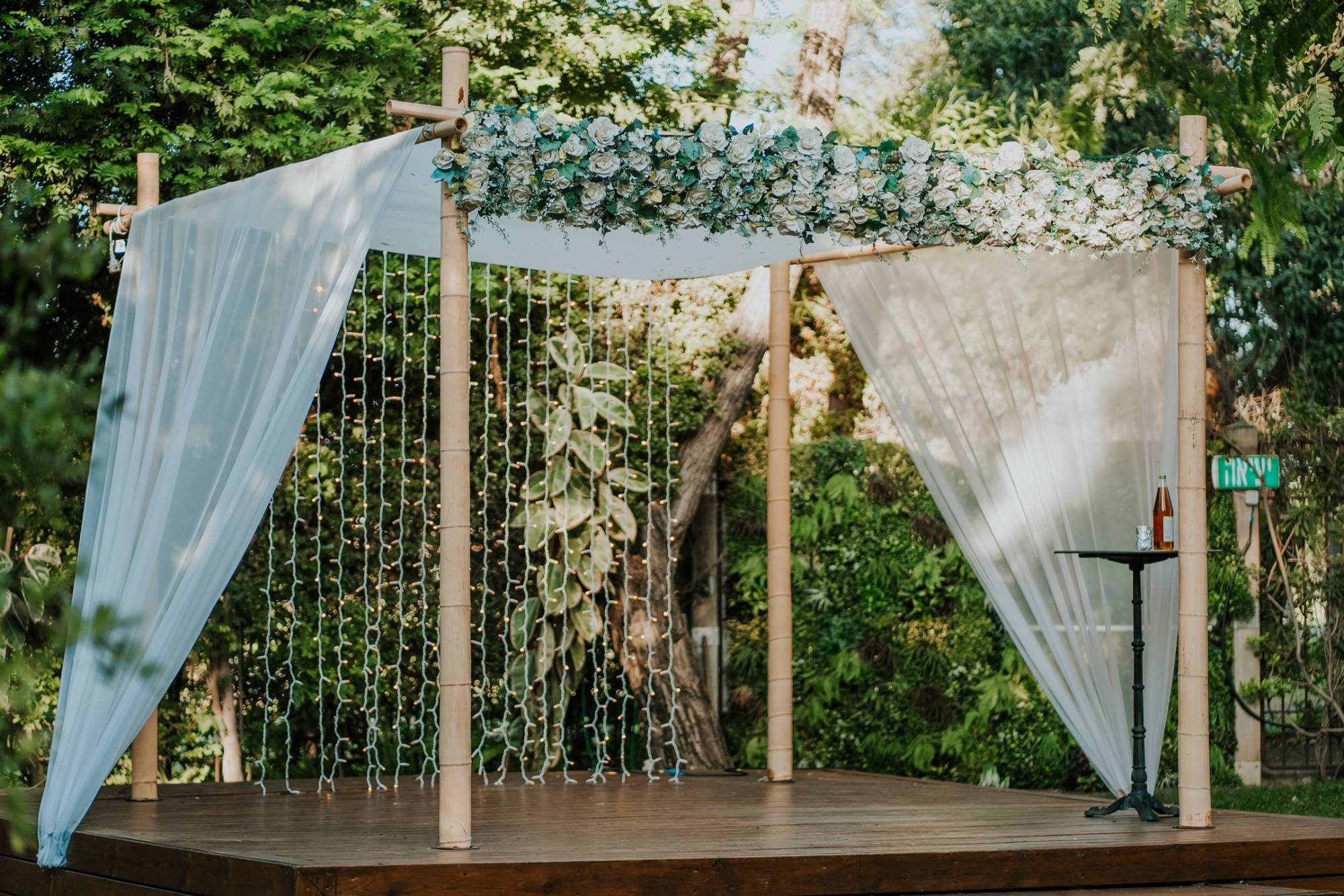 A chuppah dressed with flowers and drapes in a garden
